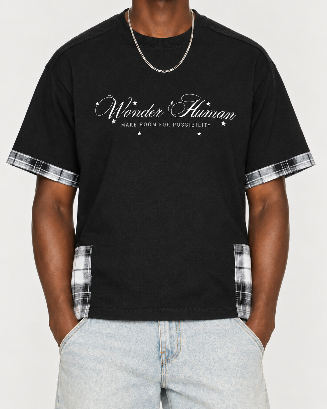 Close-up of black Plaid Panel Tee showing Wonder Human front graphic and plaid trim details
