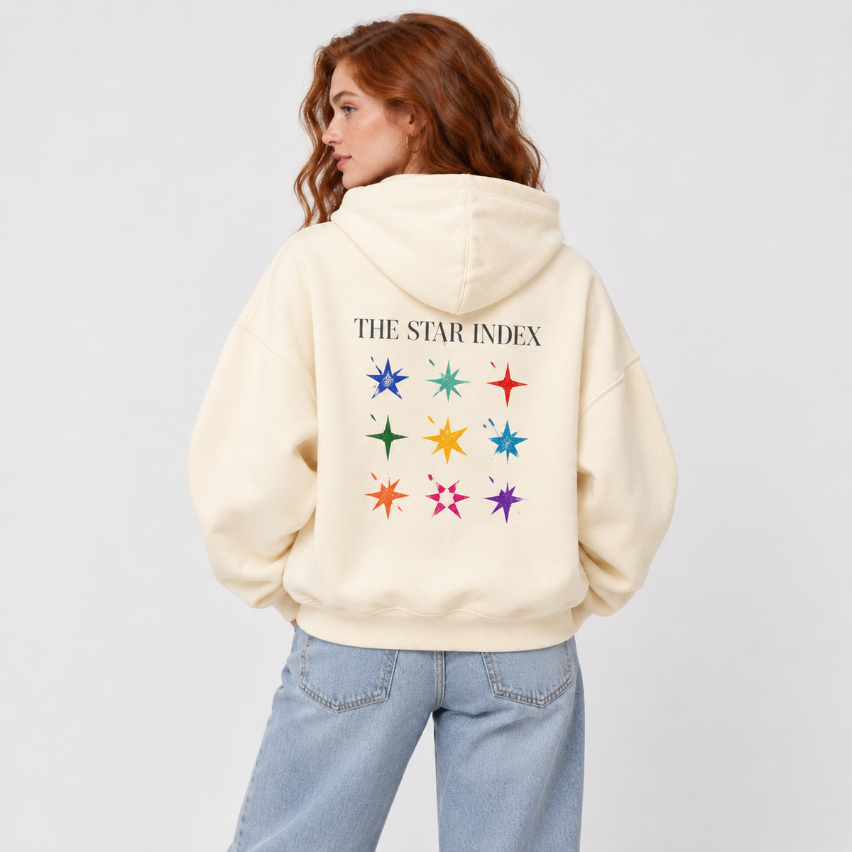 Female model wearing Apricot Star Index Hoodie, back view showing colorful Star Index graphic