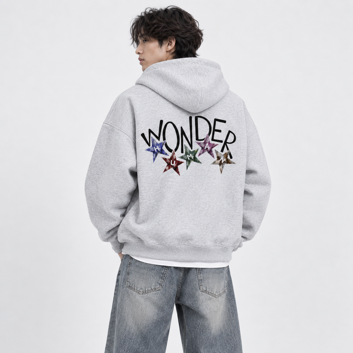 Male model wearing Flower Gray Wonder Zip Hoodie, back view showing Wonder graphic with stars