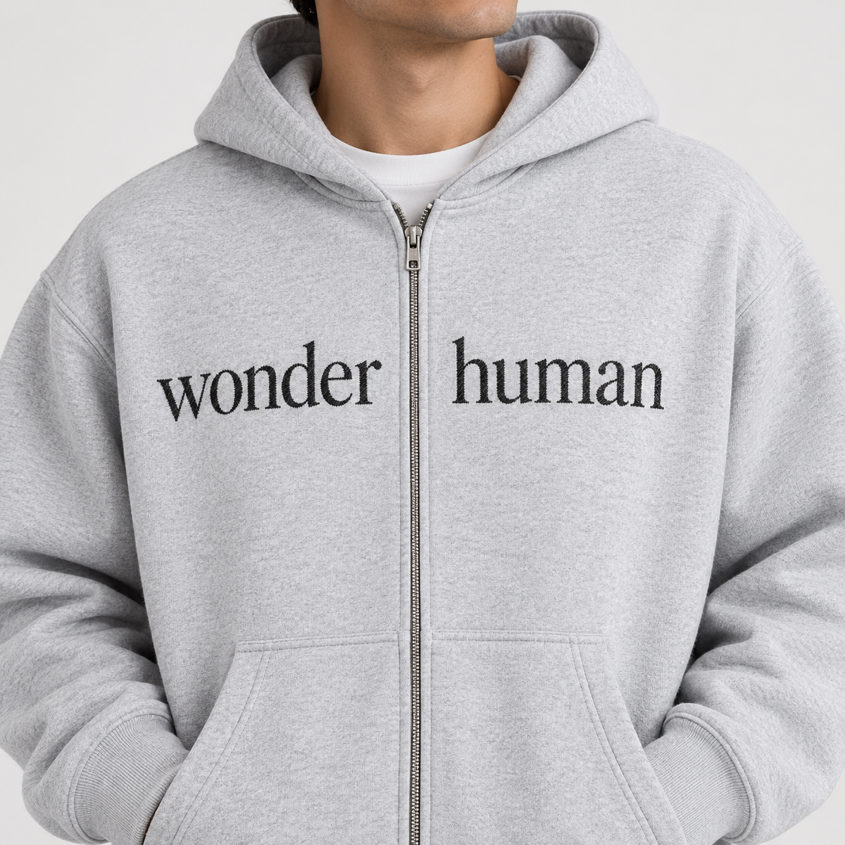 Close-up of Flower Gray Wonder Zip Hoodie showing zipper, fabric, and split Wonder Human chest logo