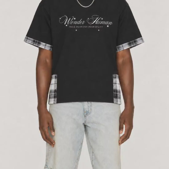 Model wearing black Plaid Panel Tee with plaid trim and Wonder Human front graphic video.